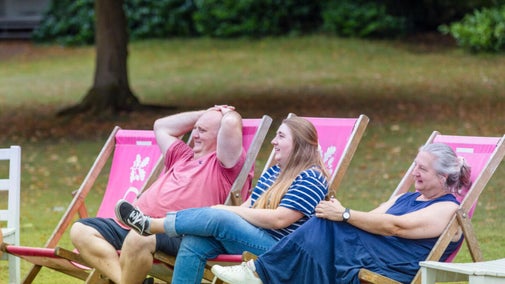 There people relaxing on pink deckchairs at Claremont Landscape Garden